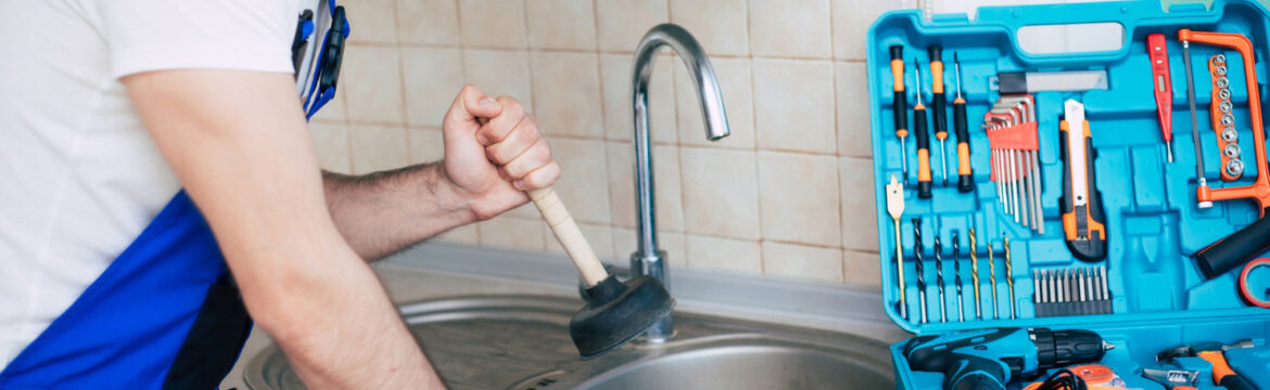 plumber using plunger to unclog kitchen sink