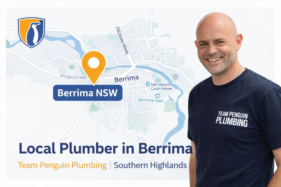 A smiling man in a Team Penguin Plumbing shirt stands next to a map of Berrima, NSW, with a location pin. Text reads: Local Plumber in Berrima. Team Penguin Plumbing | Southern Highlands.